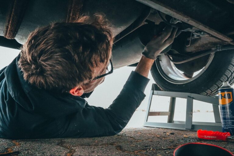 Car mechanic working on a car in a repair shop.