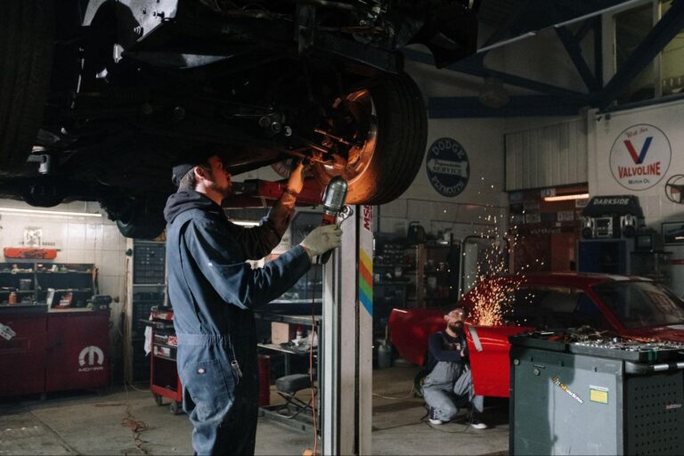 Two mechanics working on different cars